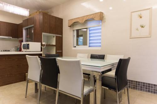 a kitchen with a dining room table and chairs at Taitung Leisure B&B in Taitung City