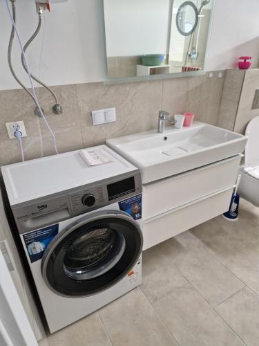 ein Badezimmer mit Waschmaschine und Waschbecken in der Unterkunft Haus Noah in Sierosław