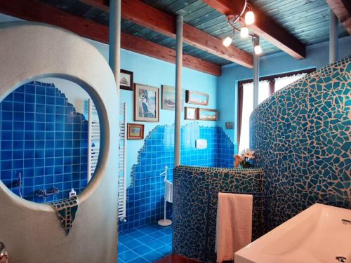 a bathroom with blue tiled walls and a mirror at Villa Chiara Affascinante Villino in Monsampolo del Tronto
