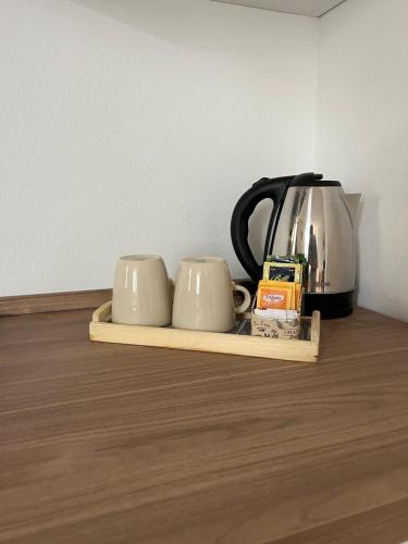 a shelf with two coffee mugs and a tea kettle at Casa da Paolino in Porto Ceresio