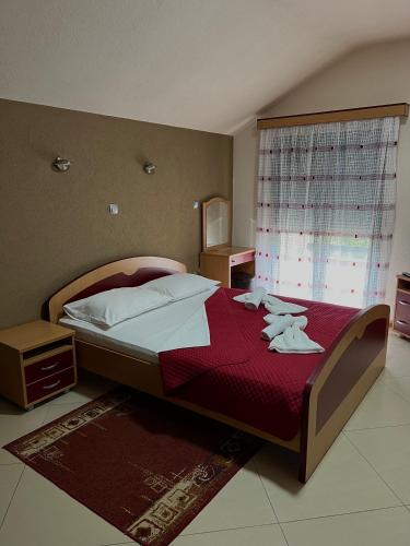 a bedroom with a large bed with a red blanket at Motel Krstac in Mojkovac