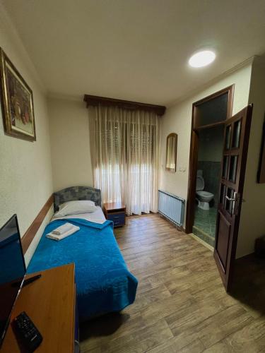 a bedroom with a bed and a desk and a television at Motel Krstac in Mojkovac