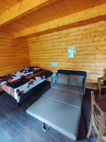 - une chambre avec un lit et un canapé dans une cabine dans l'établissement Chalet western - Retour à l'instinct primaire, à Mareuil-sur-Arnon