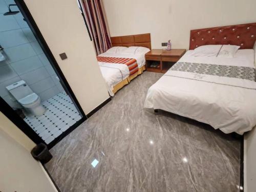 una camera d'albergo con due letti e uno specchio di Harbin Qiju Hotel Taiping International Airport a Wujia