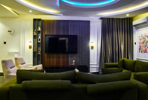 a living room with green furniture and a flat screen tv at The Blanche Apartment in Aso
