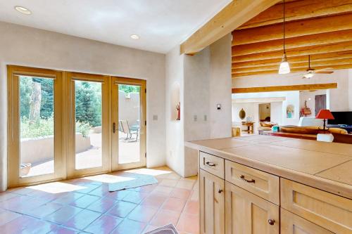 a large kitchen with a counter and a living room at Casa del Sueños in Taos