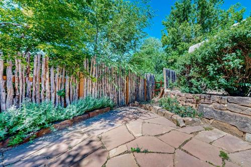 a backyard with a fence and a stone walkway at Casa del Sueños in Taos