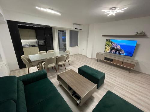 Una sala de estar con un sofá verde y una mesa. en Oskar Apartments 2, en Kočani