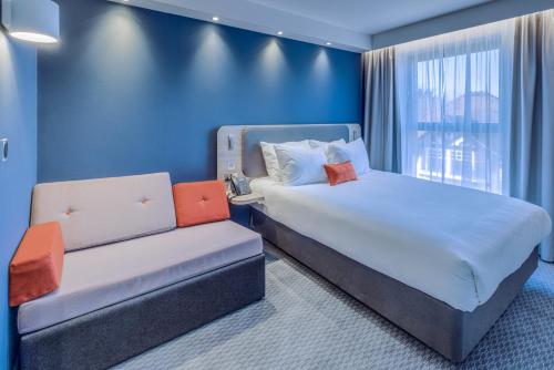 a hotel room with a bed and a couch at Holiday Inn Express - Fleet, an IHG Hotel in Fleet