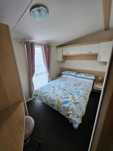 a small room with a bed and a window at Meadow Lakes 37 in Chapel Saint Leonards