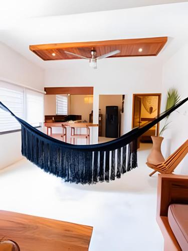 a hammock in the living room of a house at Casa Privada - Diseño ubicación y comodidad in Bacalar