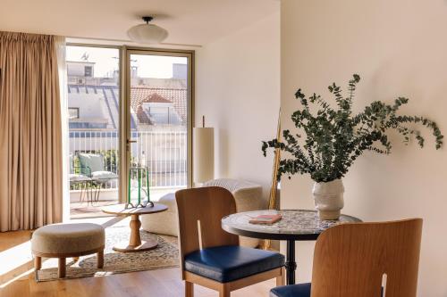 a living room with a table and chairs and a window at Locke de Santa Joana in Lisbon
