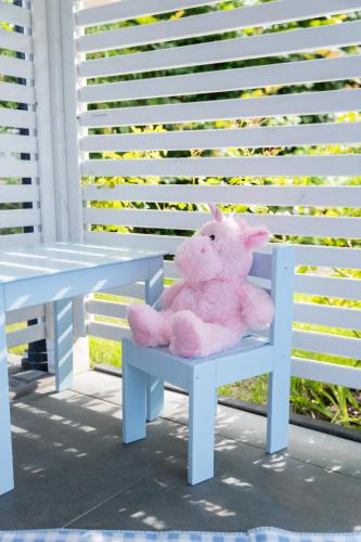 a pink teddy bear sitting on a chair next to a table at Domki Wierzbówka in Mielno
