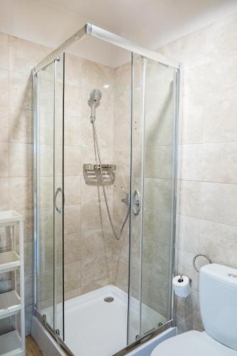 a shower with a glass door in a bathroom at Domki Wierzbówka in Mielno