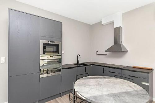 a kitchen with a sink and a stove top oven at Practical apartment near city center in Stavanger