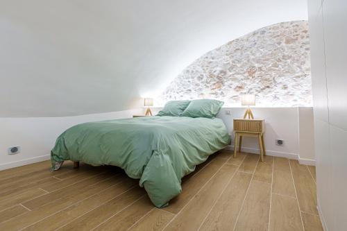 une chambre avec un lit et un mur en pierre dans l'établissement 2 pièces Cœur du Vieil Antibes, à Antibes