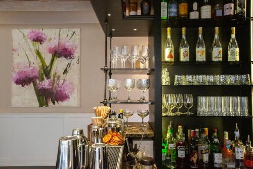 a bar with glasses and bottles of wine at Relais Villa D'Amelia in Benevello