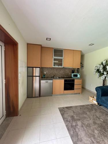 a kitchen with stainless steel appliances and a blue couch at Quinta dos Sonhos in Valbom