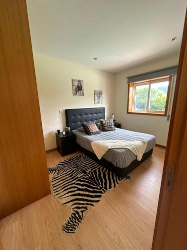 a bedroom with a bed with a zebra rug on the floor at Quinta dos Sonhos in Valbom