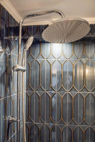 a shower with a tiled wall and a shower head at Gorgona Traditional 3 in Karpathos