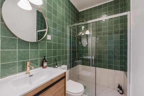 une salle de bain carrelée verte avec un lavabo et des toilettes dans l'établissement Setubal Terrace apartments, à Setúbal