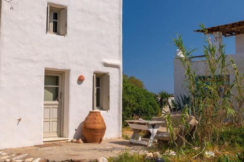 a white building with a large vase in front of it at Kiter's paradise beach house in Pounda