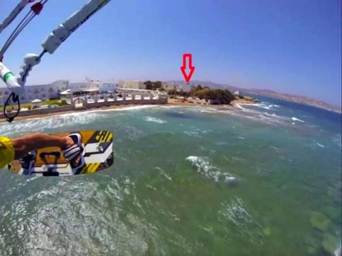a man riding a parachute over a body of water at Kiter's paradise beach house in Pounda