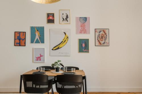 a dining room table with chairs and pictures on the wall at Setubal Terrace apartments in Setúbal