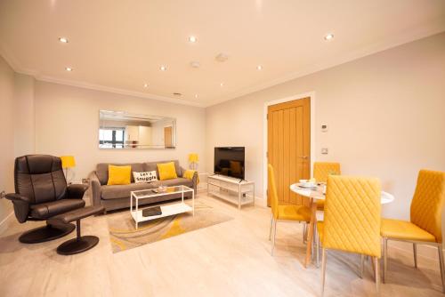 a living room with a couch and a table and chairs at Malthouse Court in Reading