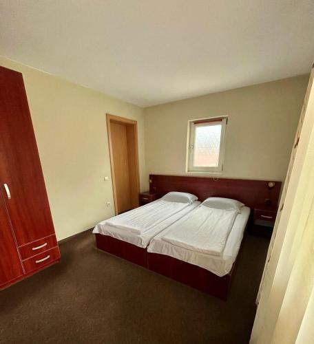 a bedroom with a bed and a window at Pensiunea BUJOR DE MUNTE in Voineasa