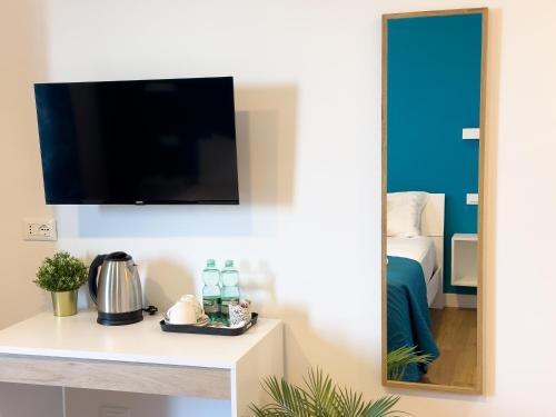 a room with a tv and a table with a mirror at ISOLA 163 Guest House in Fiumicino