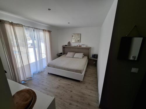 une petite chambre avec un lit et une télévision dans l'établissement Maison de standing au calme pour vacances, au Beausset