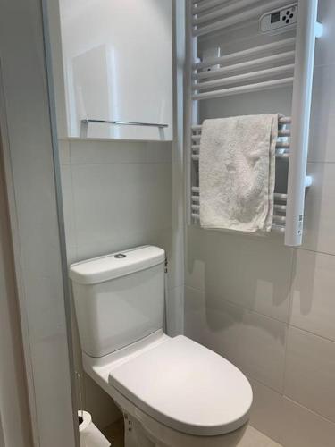 - une petite salle de bains blanche pourvue de toilettes et de serviettes dans l'établissement Havre de paix en centre ville, à Marseille