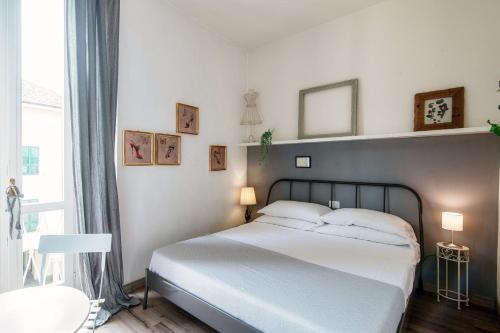 科莫Glamour - by MyHomeInComo的卧室里有一张白色的床和一扇大窗户