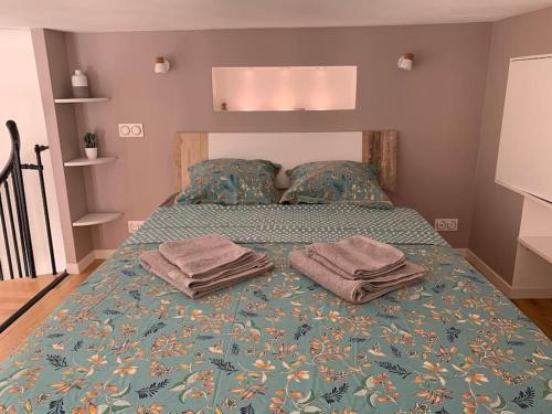 une chambre avec un lit avec deux serviettes dessus dans l'établissement Havre de paix en centre ville, à Marseille