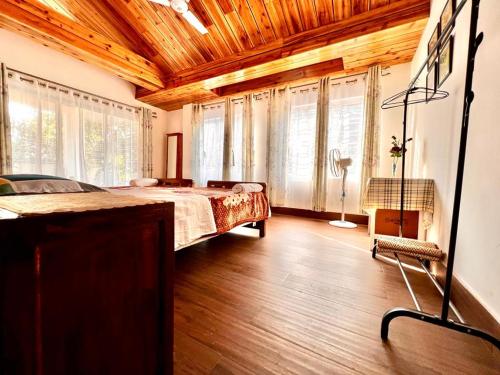 a bedroom with a bed and a wooden ceiling at Dale Villa in Borpāni