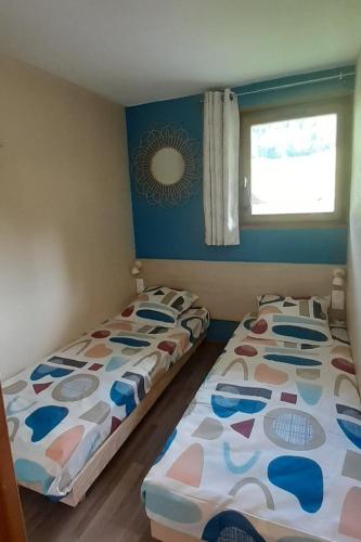 deux lits côte à côte dans une chambre dans l'établissement Appartement 4 personnes aux Bottières Résidence le Bochate sur le domaine des Sybelles en Savoie, à Saint-Pancrace