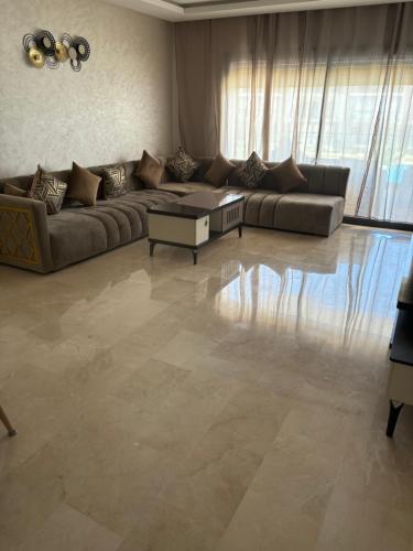 a living room with a couch and a table at Tamaris in Dar Bouazza