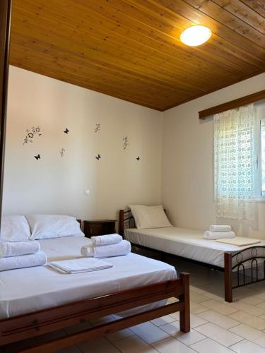 a bedroom with two beds and a wooden ceiling at -Tsiakos Apartment- in Vryses in Kyparissia