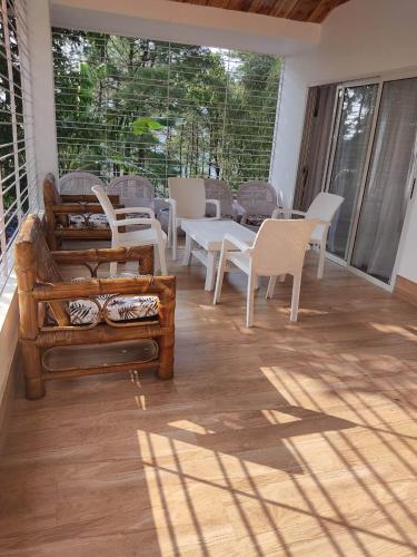 a screened in porch with chairs and a table at Dale Villa in Borpāni