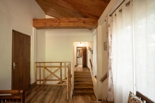 a hallway with wooden ceilings and wooden stairs at Dale Villa in Borpāni