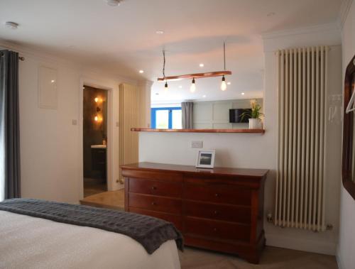 a bedroom with a bed and a dresser and a mirror at The Garden retreat in Killarney