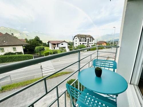 a blue table and chairs on a balcony with a street at Le Golden Lake-5min du LAC à pied-Parking privé gratuit in Sévrier
