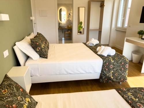 a bedroom with a large white bed and two chairs at ISOLA 163 Guest House in Fiumicino