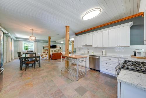 a kitchen with white cabinets and a table in it at Peaceful Warrenville Home 1 Mi to Herrick Lake! in Warrenville