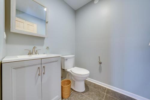 a white bathroom with a toilet and a sink at Peaceful Warrenville Home 1 Mi to Herrick Lake! in Warrenville