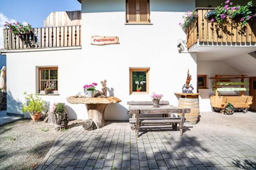 a courtyard of a house with a table and a bench at Engethalerhof in Pavicolo
