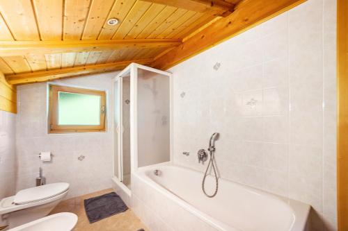 a bathroom with a white tub and a toilet at Engethalerhof in Pavicolo