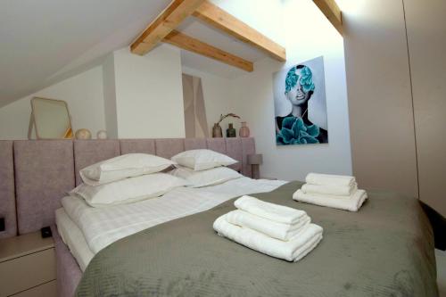 a bedroom with a large bed with towels on it at Apartamenty Blanca in Łeba