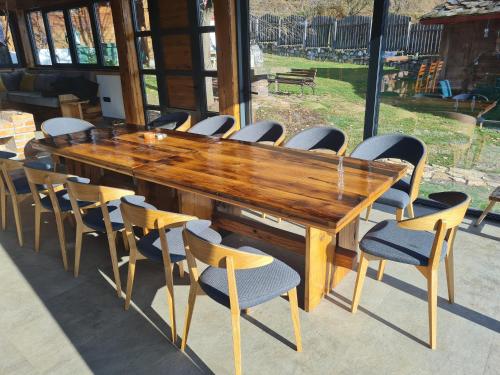 a large wooden table with chairs around it at Drinsko selo Ovčinja in Ovčinja